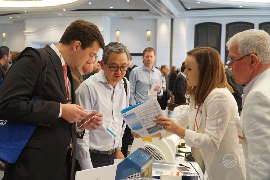 Attendees and an exhibitor discussing equipment at a previous IVC meeting