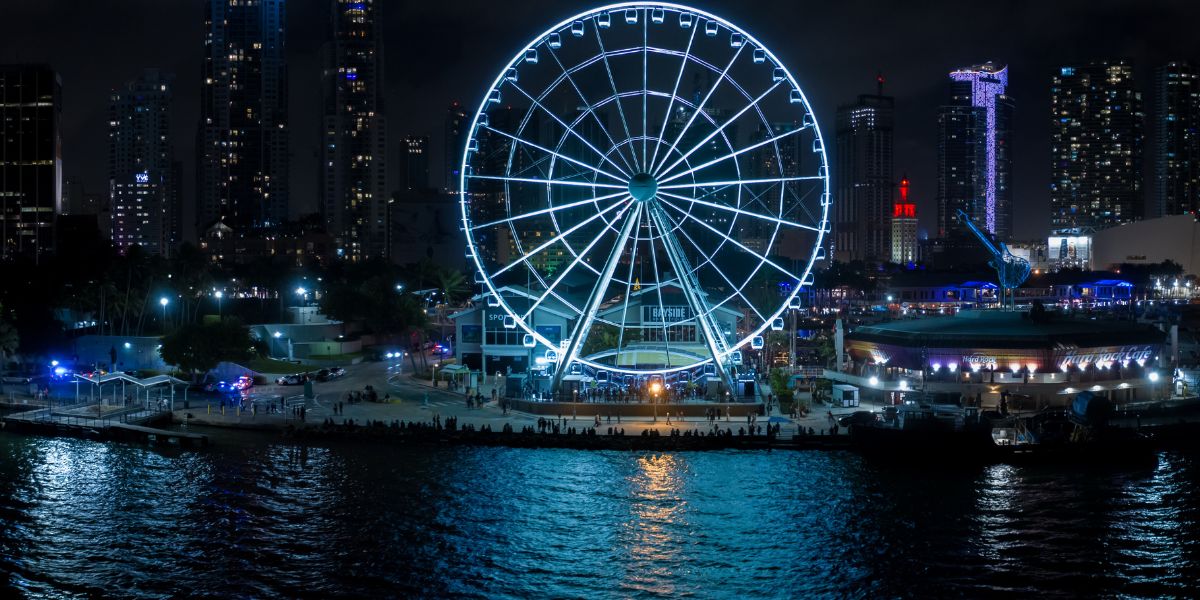 Bayside Marketplace and its illuminated observation wheel beside the bay at night